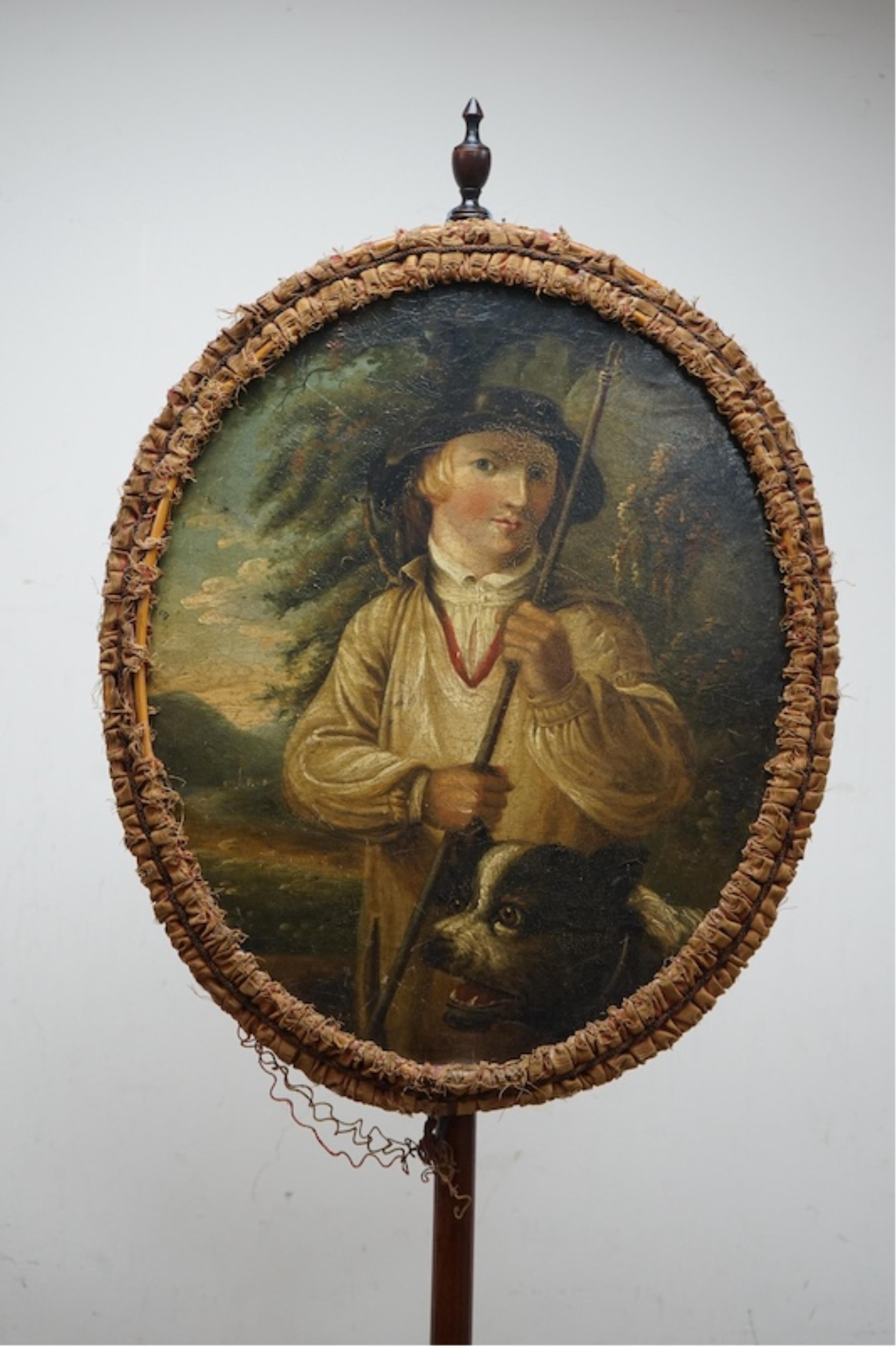 An oval Regency fire screen painting of a shepherd boy with his dog and a painting verso of ephemera, the screen edged with rushed ribbon fixed to a simple mahogany stand. 130cm high. Condition - paintings crazed and rib